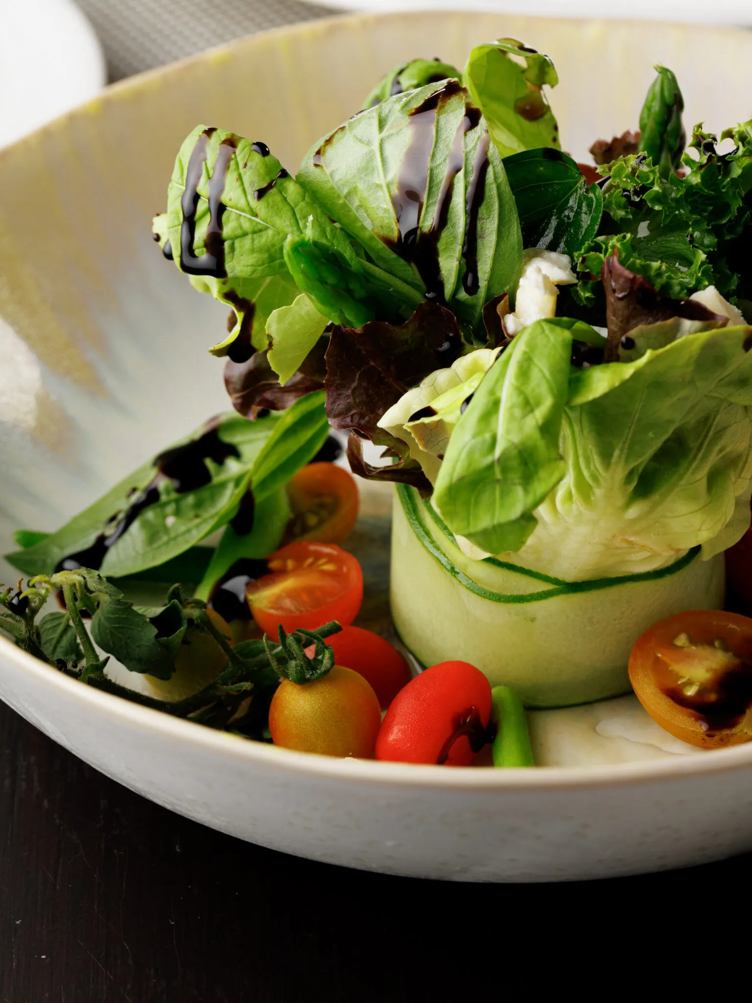 Refreshing asparagus and tomatoes salad topped with feta cheese and balsamic reduction from the pillars restaurant menu
