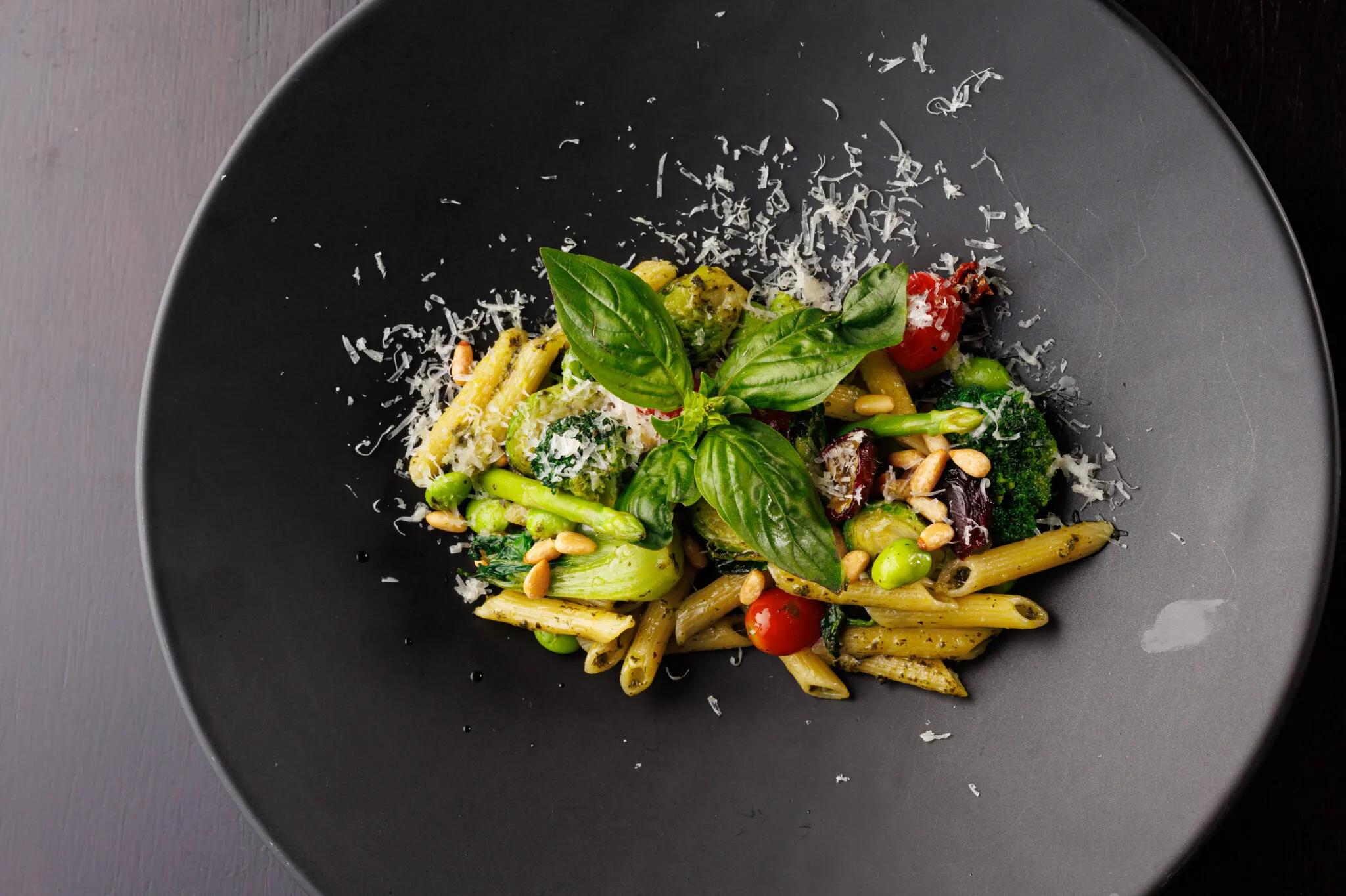 Vibrant pesto pasta main course with asparagus, broccoli, and Brussels sprouts from the pillars restaurant menu