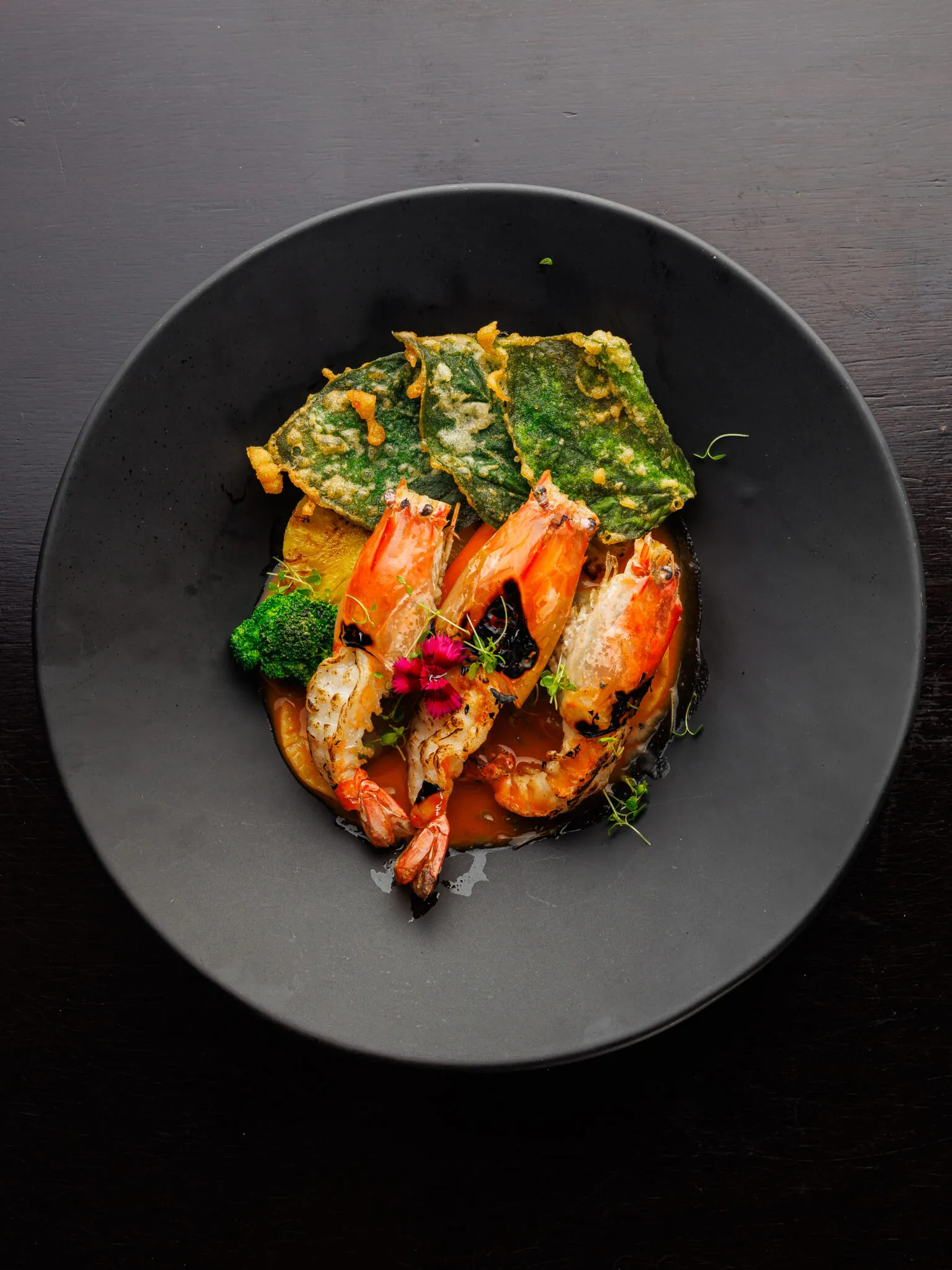 Plate of river prawns with mushroom ravioli and red curry sauce, a main course option from the pillars restaurant menu