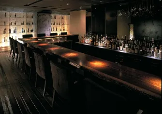 A classic, dark-wood bar with bottles displayed, emphasizing a traditional and upscale bar setting.