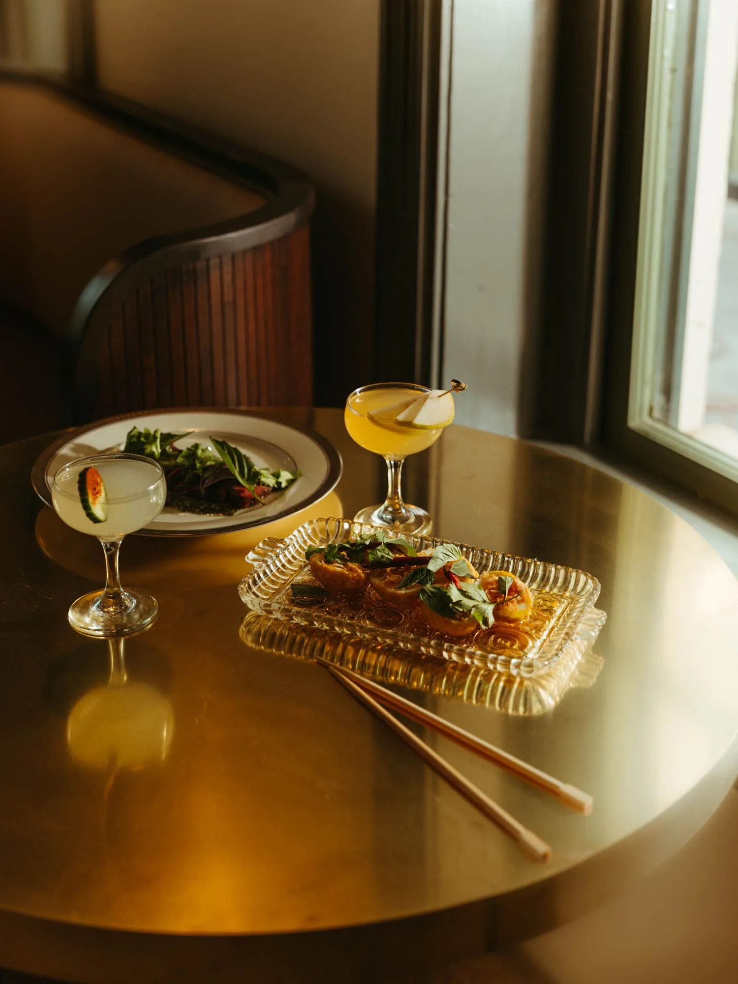 Curated food and drinks from the allintitle:new tokyo japanese restaurant menu are displayed on a brass countertop at Tokyo Cowboy