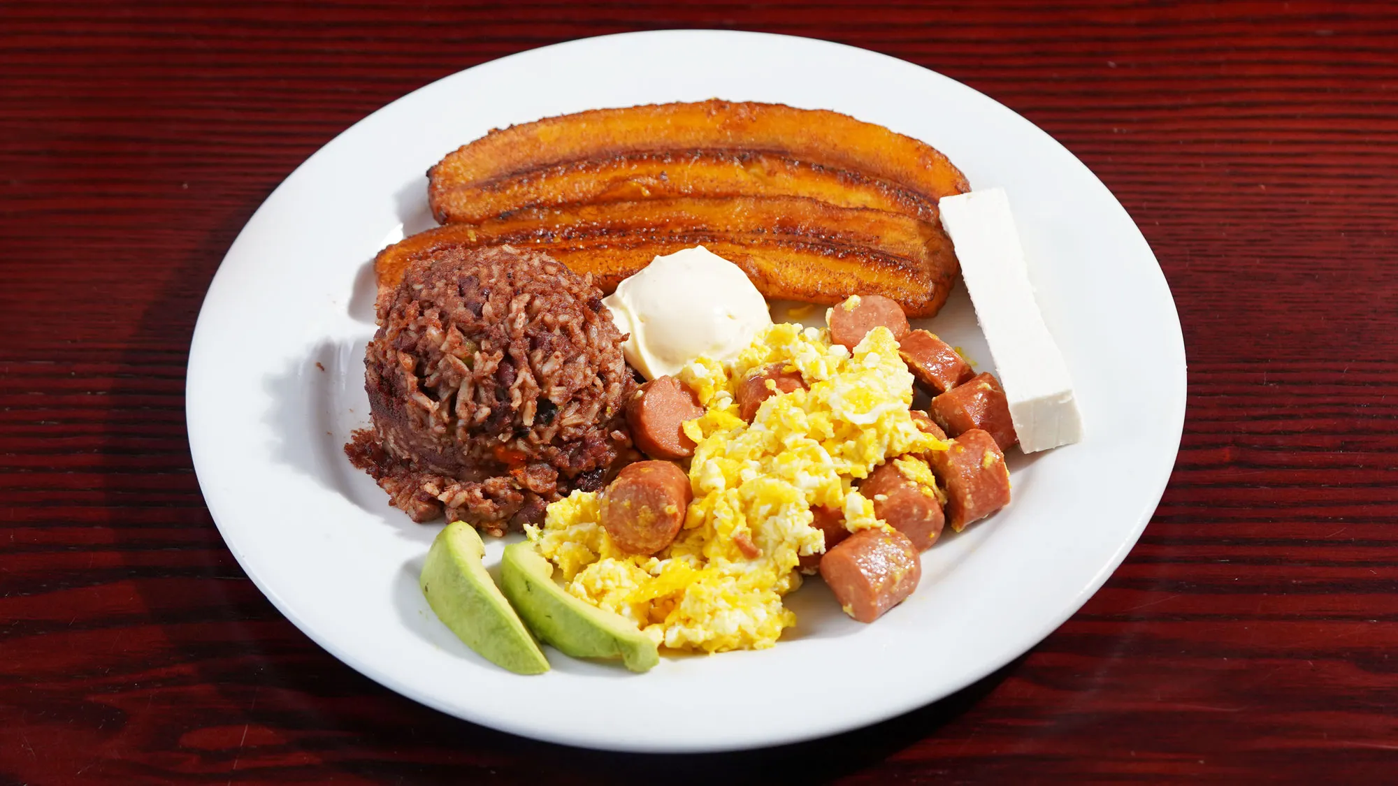 Scramble eggs with sausage, fried plantains, and beans from the armenia restaurant menu