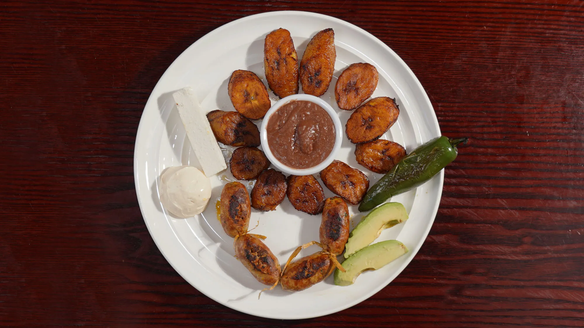 Grilled chorizo served with plantains, a popular item on the armenia restaurant menu