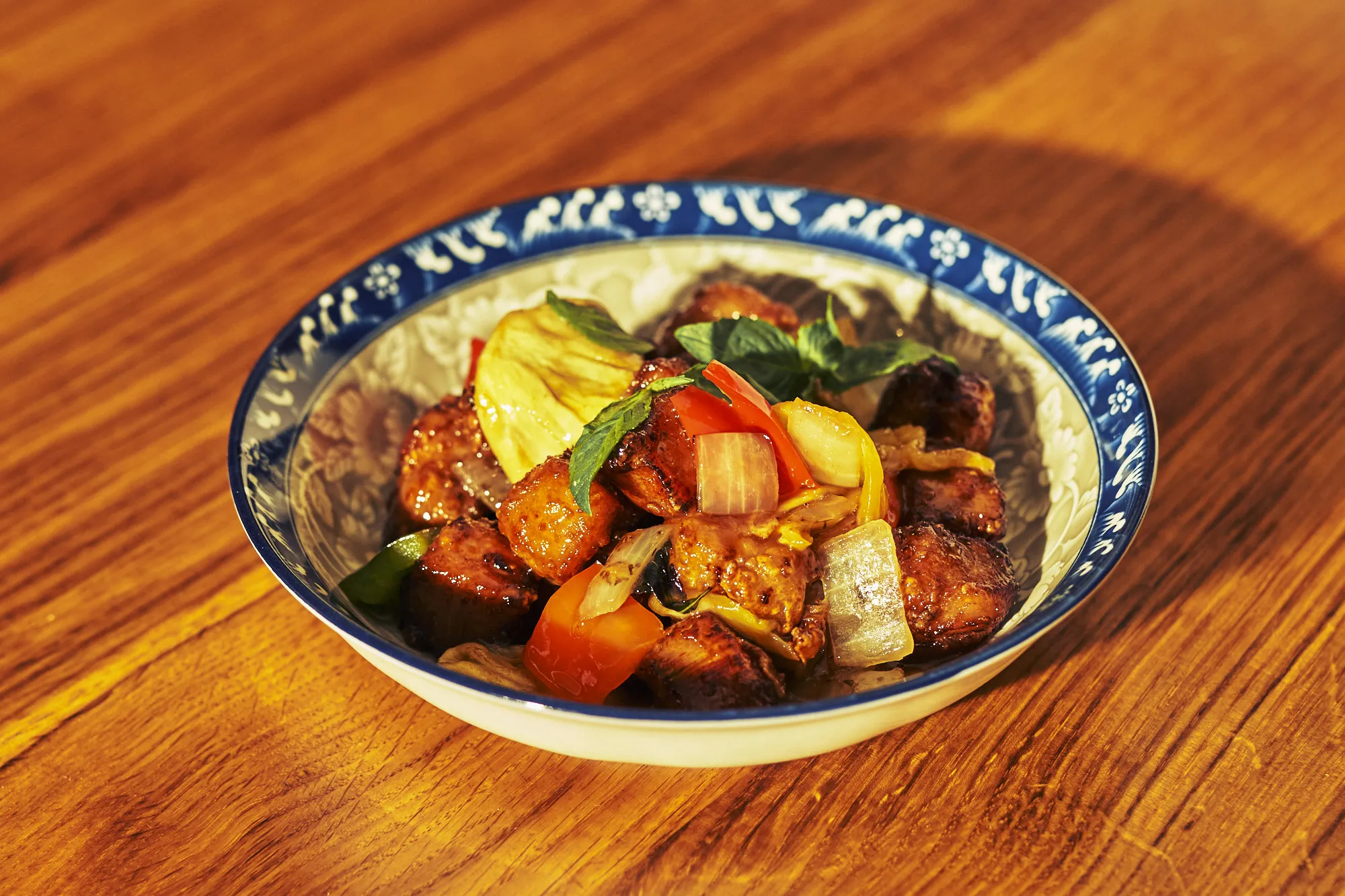 Innovative sweet-and-sour pork from a unique Chinese restaurant menu, presented in a vibrant blue-and-white bowl, showcasing culinary creativity.