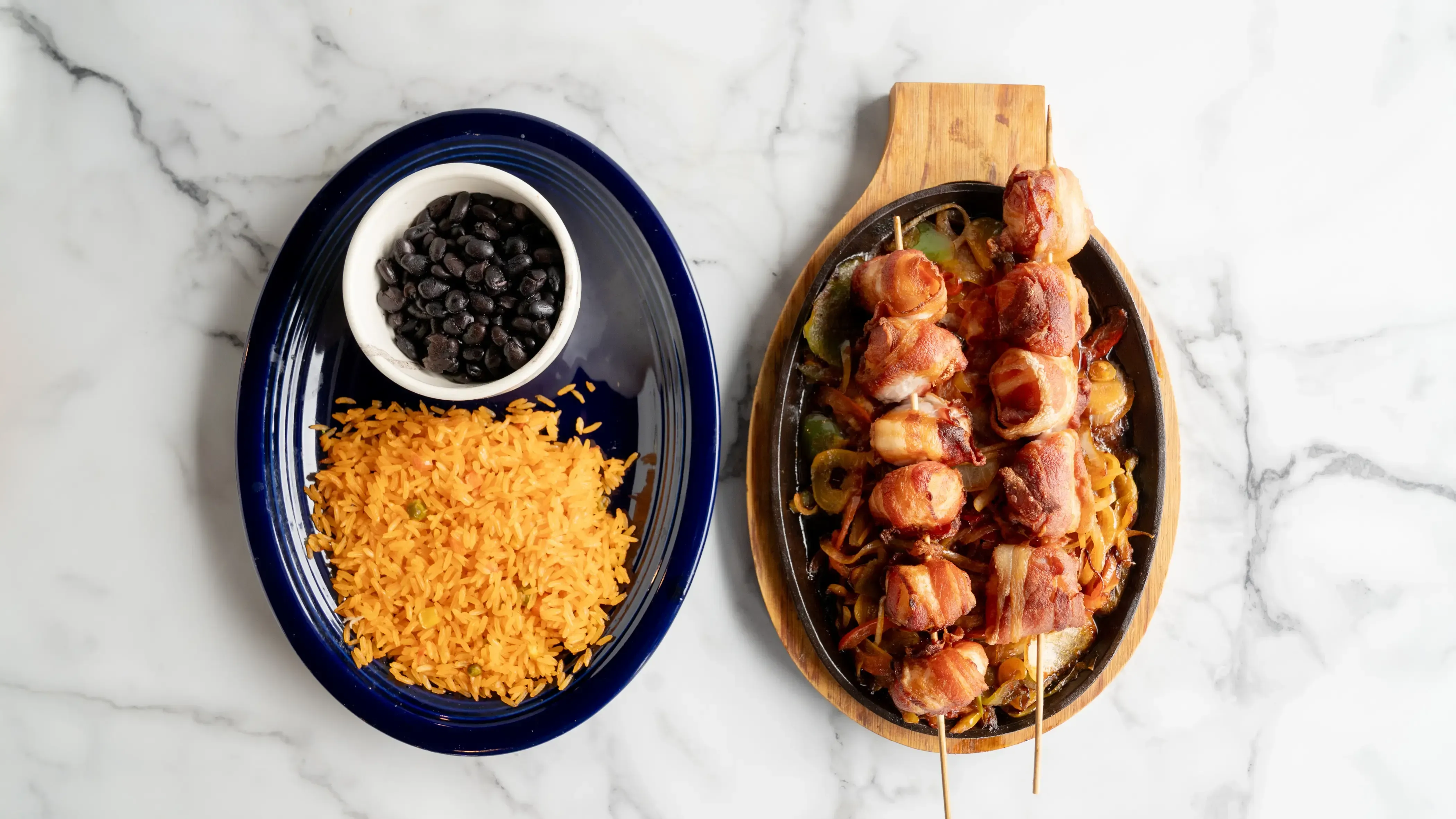 Brochetas - Ten jumbo shrimp stuffed with cheese and jalapeño slices, wrapped in crispy bacon. Served on a bed of mixed vegetables with Mexican rice and charro beans
