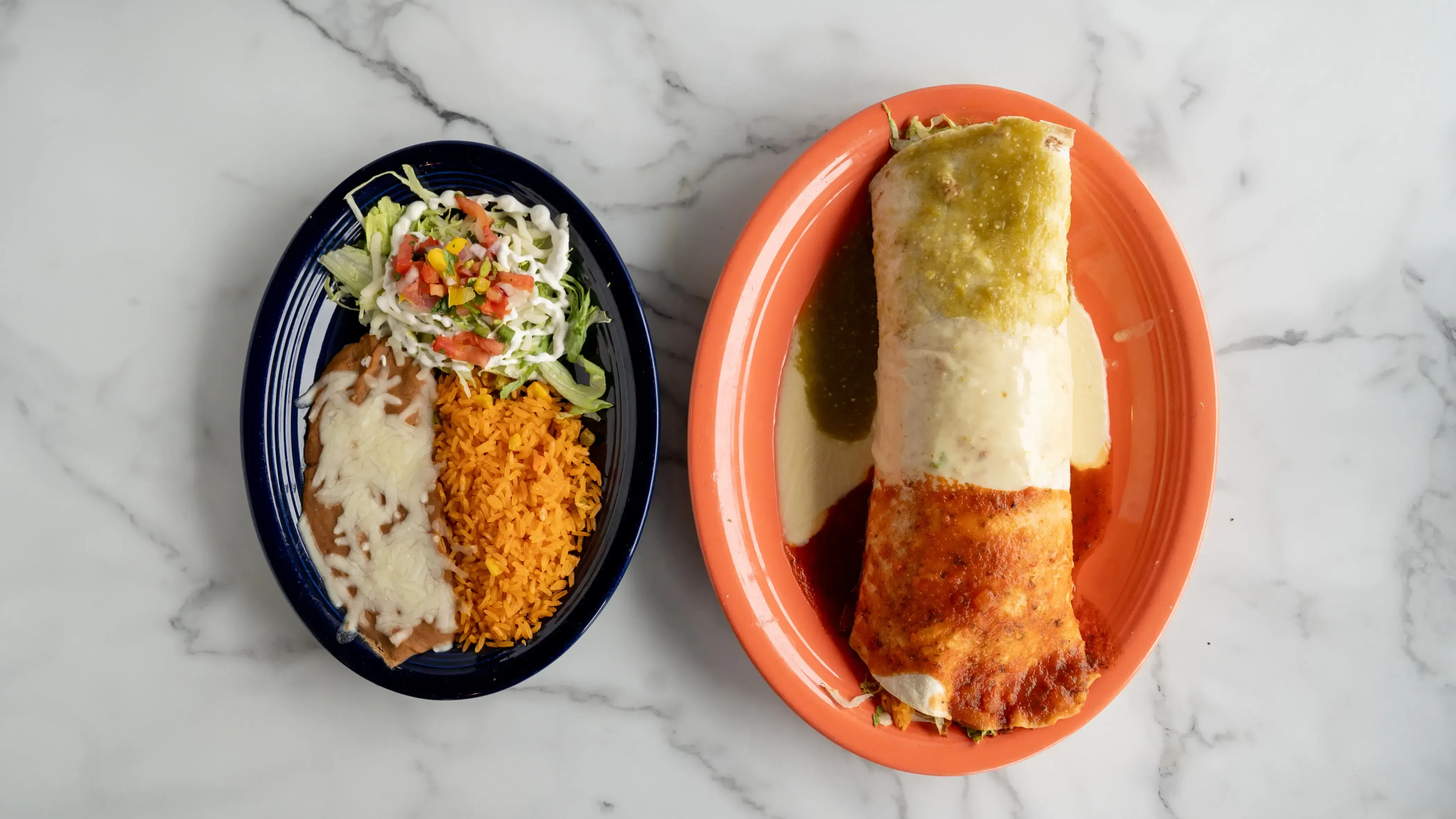 Burrito casa real - Large flour tortilla filled with your choice of protein, black beans, Mexican rice, lettuce, sour cream, fresh jalapeños, and pico de gallo. Covered with melted cheese and red and green sauces
