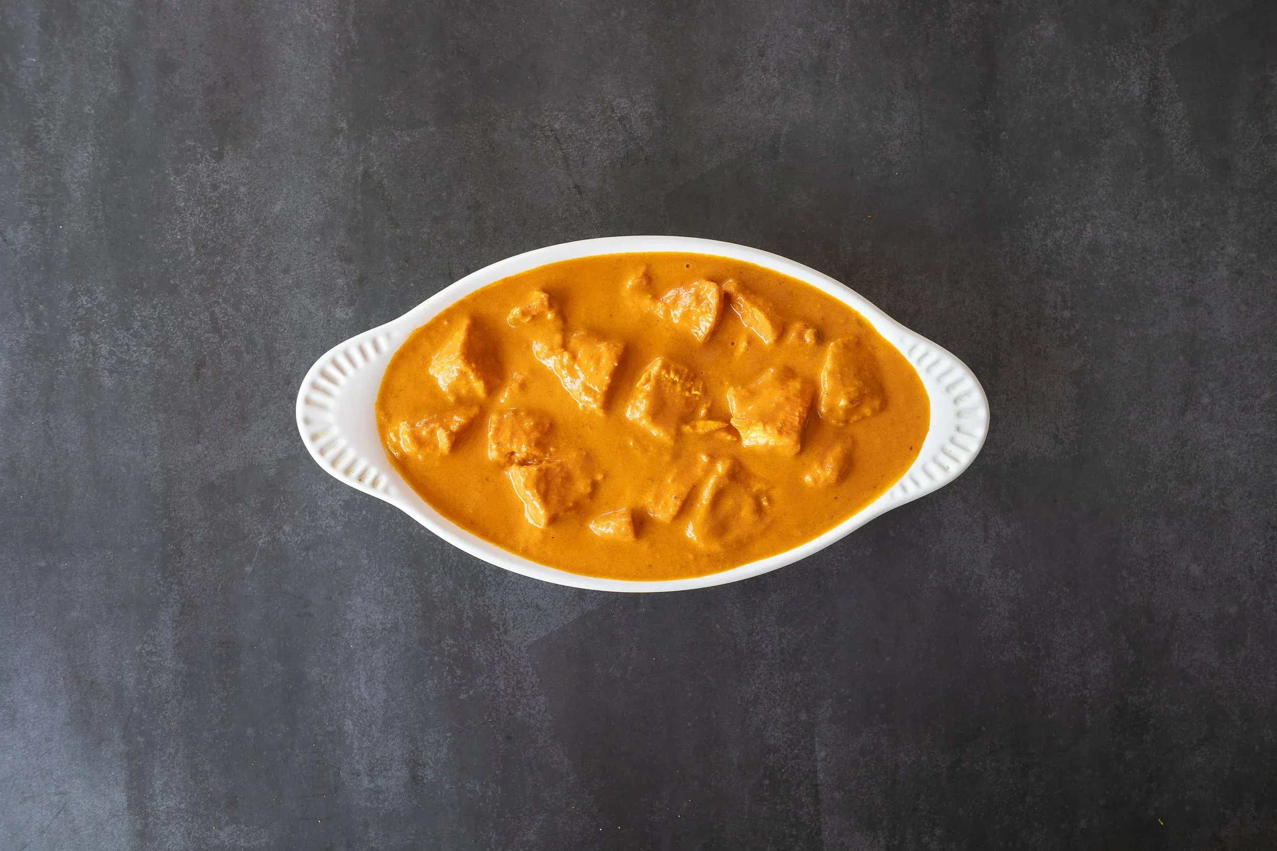 Chicken Tikka Masala, a world-renowned dish from our bollywood indian restaurant menu, with tender chicken in a creamy, spiced tomato sauce.