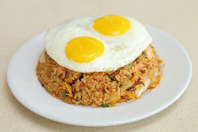 A close-up of Kenny's Kim Chee Fried Rice with Two Eggs, highlighting the vibrant kenny's restaurant menu