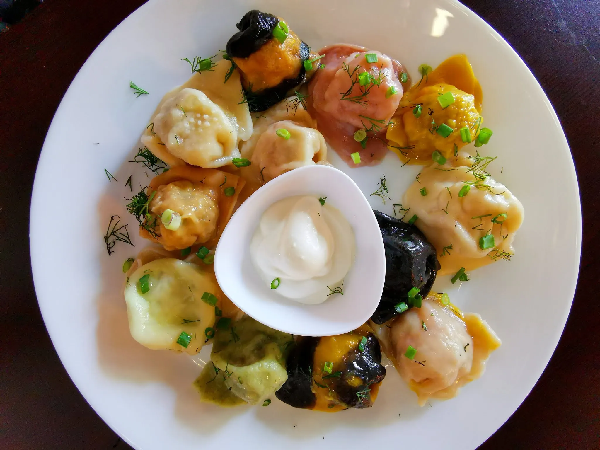 Assortment of colorful Russian dumplings (pelmeni) with various fillings from a Russian menu restaurant