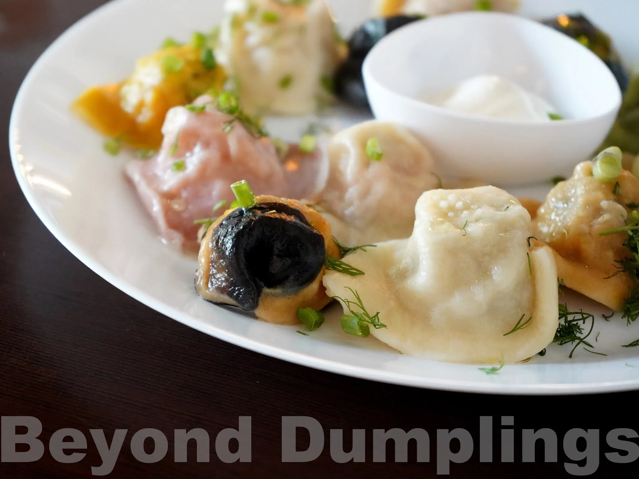 A table at Dumplings.RU, a Russian menu restaurant, featuring a meal spread and various beverages, including Kompot and Chili Vodka