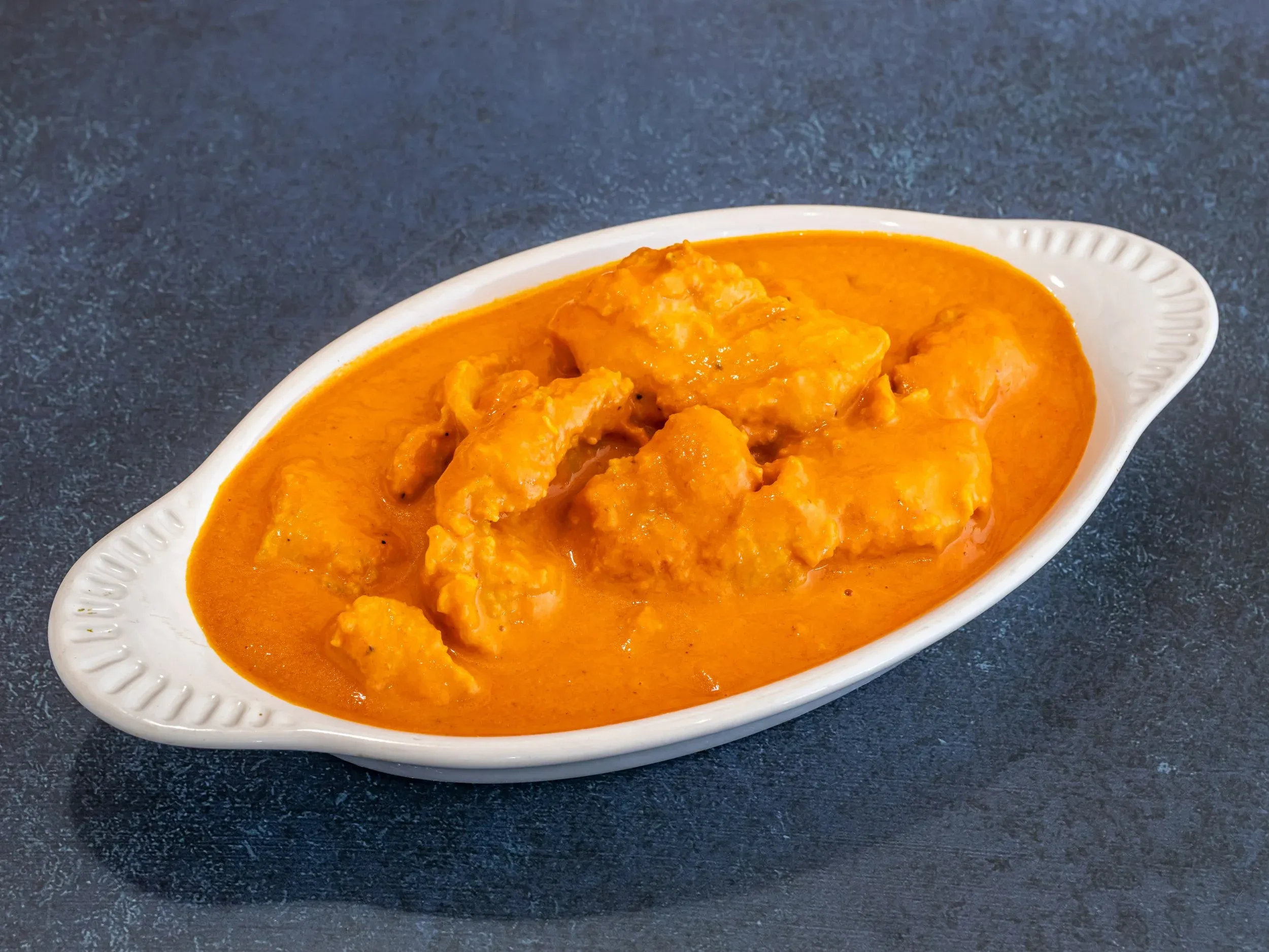 Fish Tikka Masala, a delicate seafood offering from our bollywood indian restaurant menu, with spiced fish in a creamy tomato sauce.
