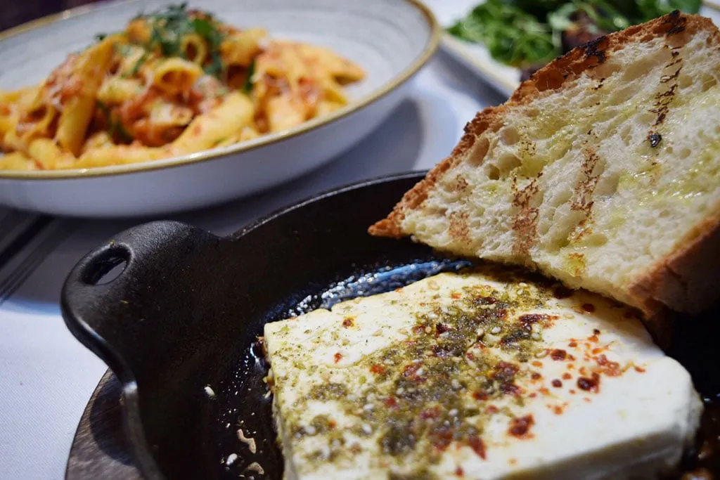 Baked feta appetizer with za'atar, chiles, and country bread from the menu majestic restaurant