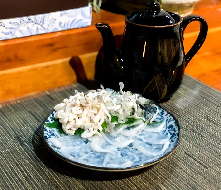 Delicate fugu sashimi elegantly arranged on a serving plate from the shiki japanese restaurant menu
