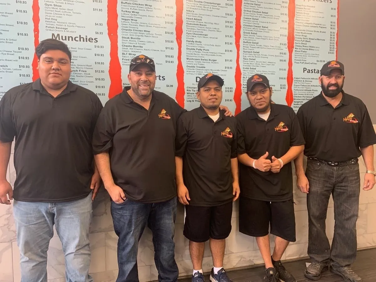 New owner Gabriel Jaramillo and manager Jose Verdin showcasing the refreshed entrance, emphasizing the continuity of Niko's Pizzeria menu in Joliet.