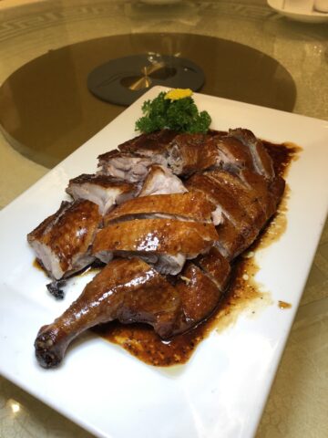 Perfectly roasted crispy London duck with black truffle sauce, a signature dish from the Asia Garden Chinese Restaurant Menu