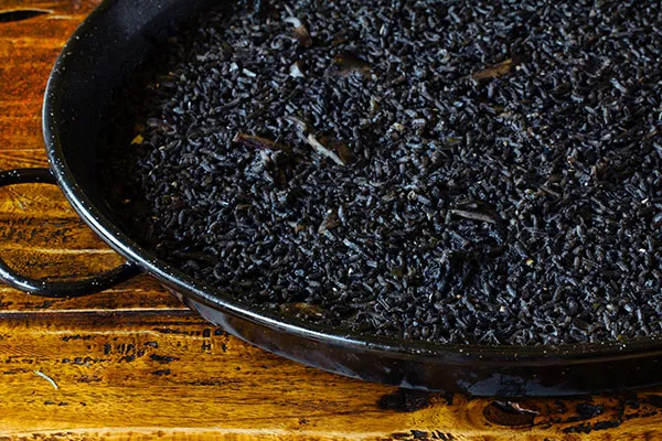 Intensely flavorful Paella Negra, a must-try seafood specialty from an authentic cebu restaurant menu.