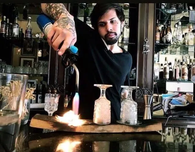 Bartender crafting a sophisticated cocktail from the Kalypso Restaurant menu