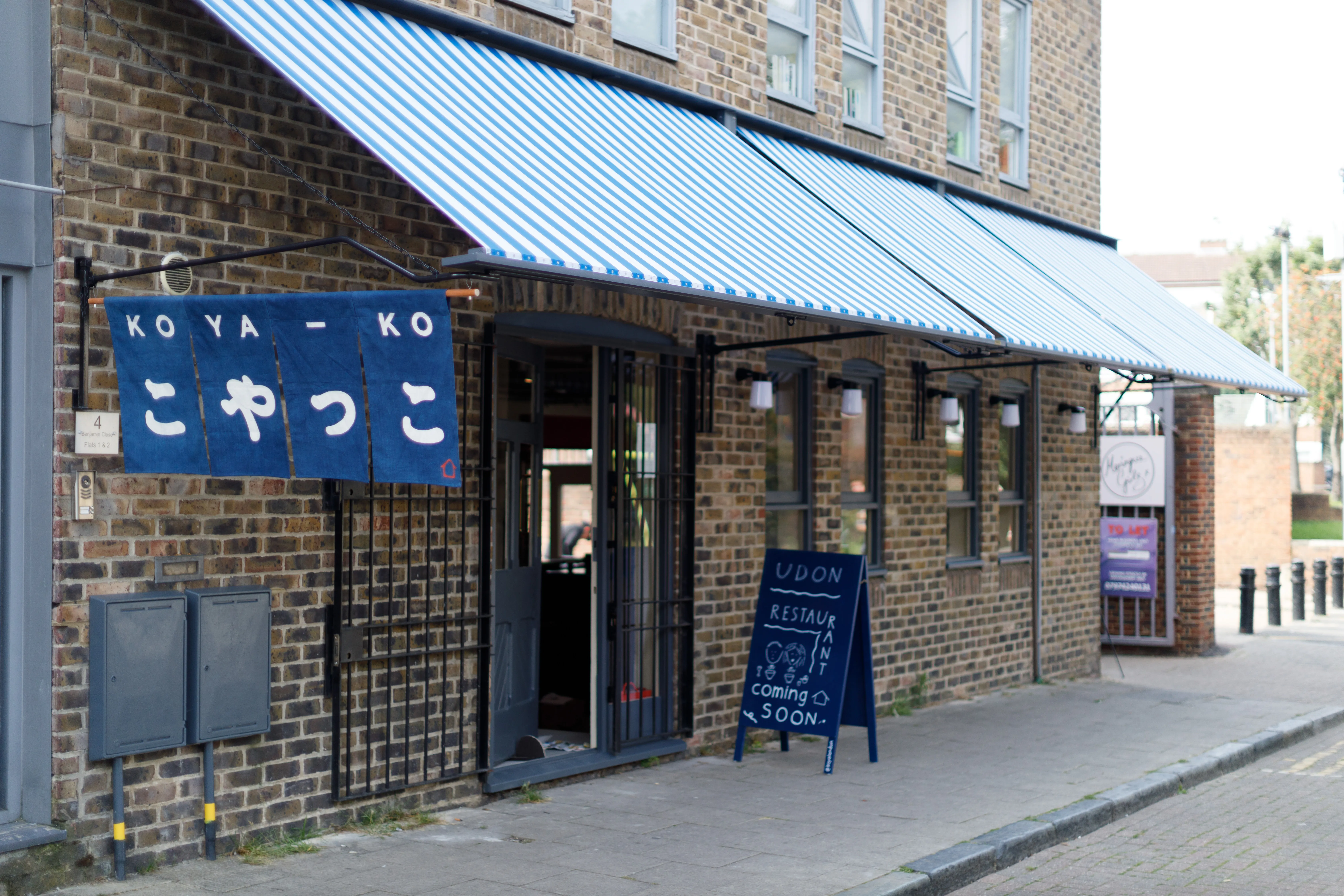 Koya Ko restaurant exterior on Broadway Market, showcasing its distinctive denim-blue signage and name in English and Japanese.