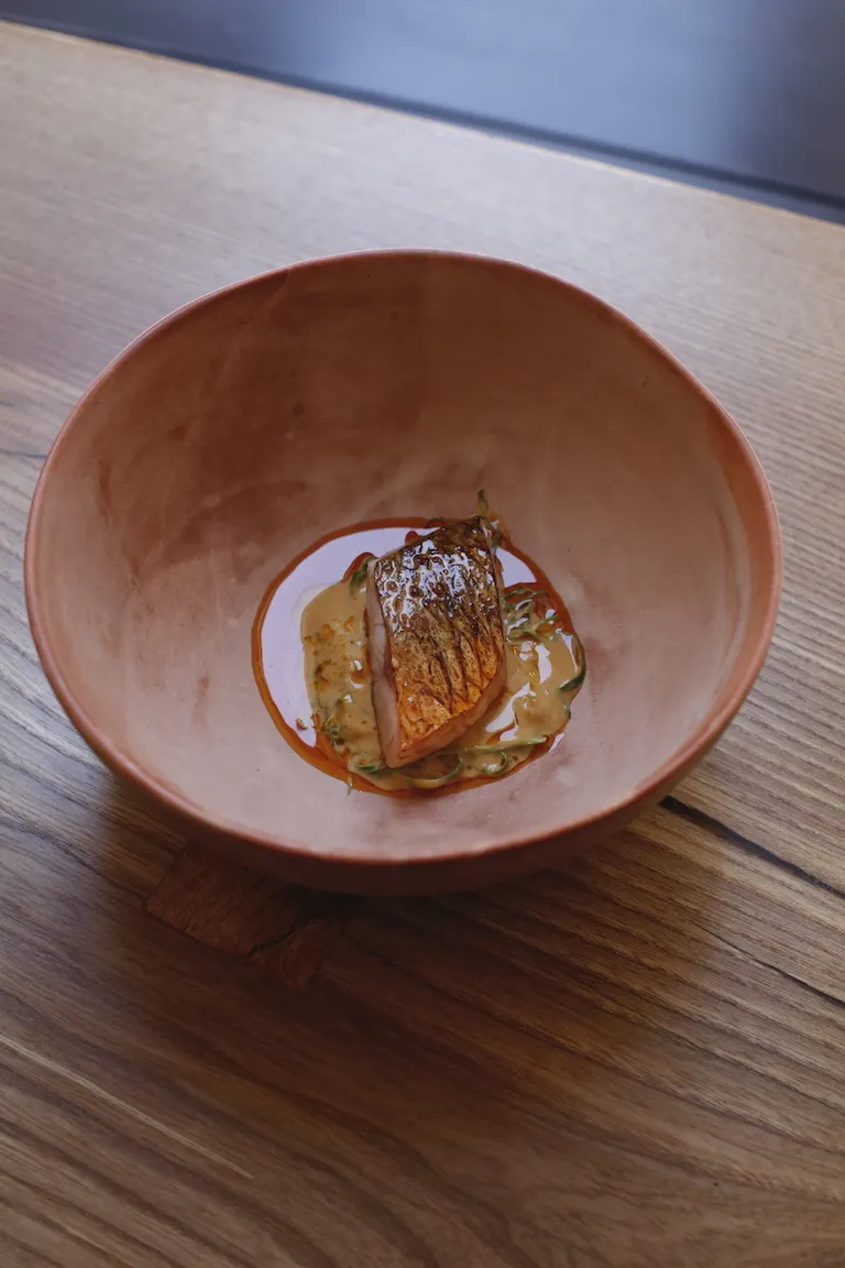 A perfectly plated Monkfish curry from the revamped Ikoyi restaurant menu, showcasing the Michelin-starred establishment's streamlined, comfort-focused dishes in St James’s Market, central London.