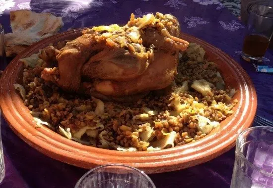Rich and aromatic Rfissa, a traditional Moroccan chicken dish served on shredded m'semmen, offering a depth rarely found on a typical Moroccan restaurant menu