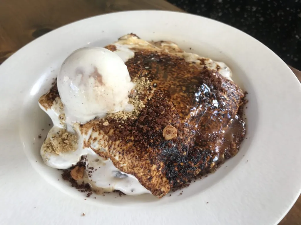A decadent S'mores Blondie, showcasing gooey marshmallow and rich chocolate, a must-try dessert from the moxie's restaurant menu