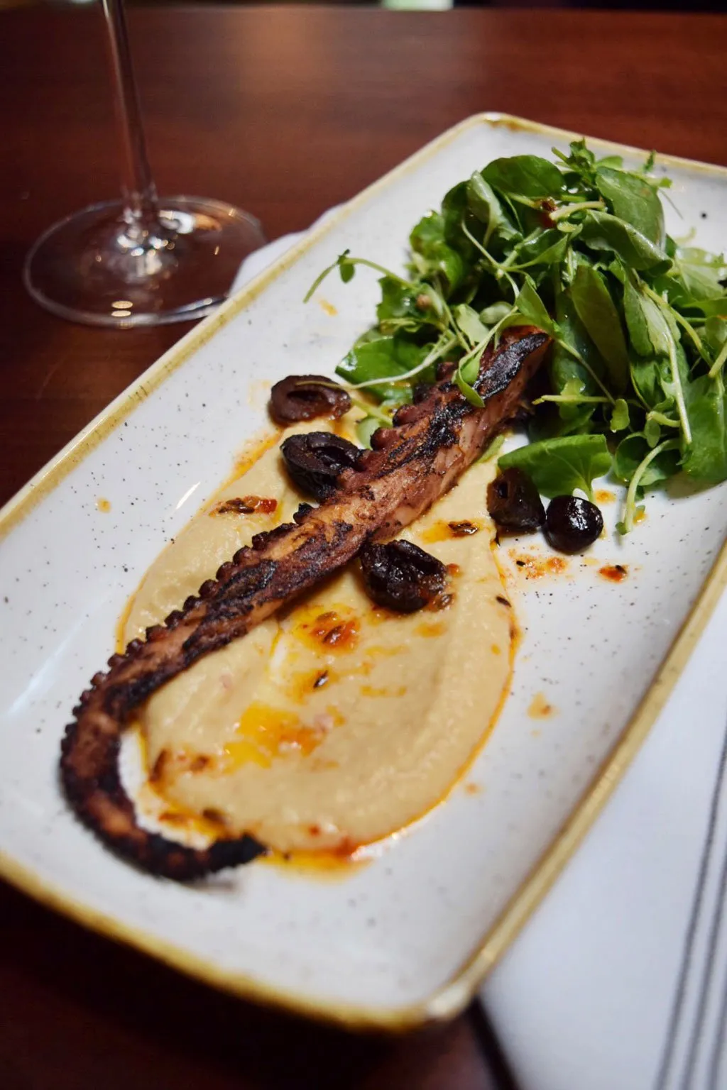 Charred octopus dish with chickpea puree, olives, and arugula—a highlight of The Majestic's menu
