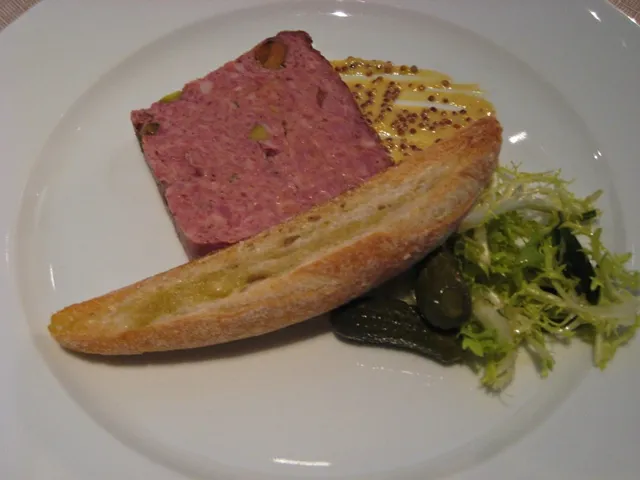 A rich and savory country terrine served with grainy mustard, frisée salad, cornichons, and toasted baguette at Ai Fiori, a more substantial appetizer option from the ai fiori restaurant week menu