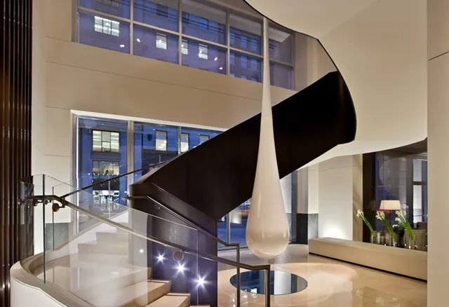 A grand, sweeping staircase with elegant lighting leading up to the Ai Fiori dining room, showcasing the refined entrance for a memorable ai fiori restaurant week experience