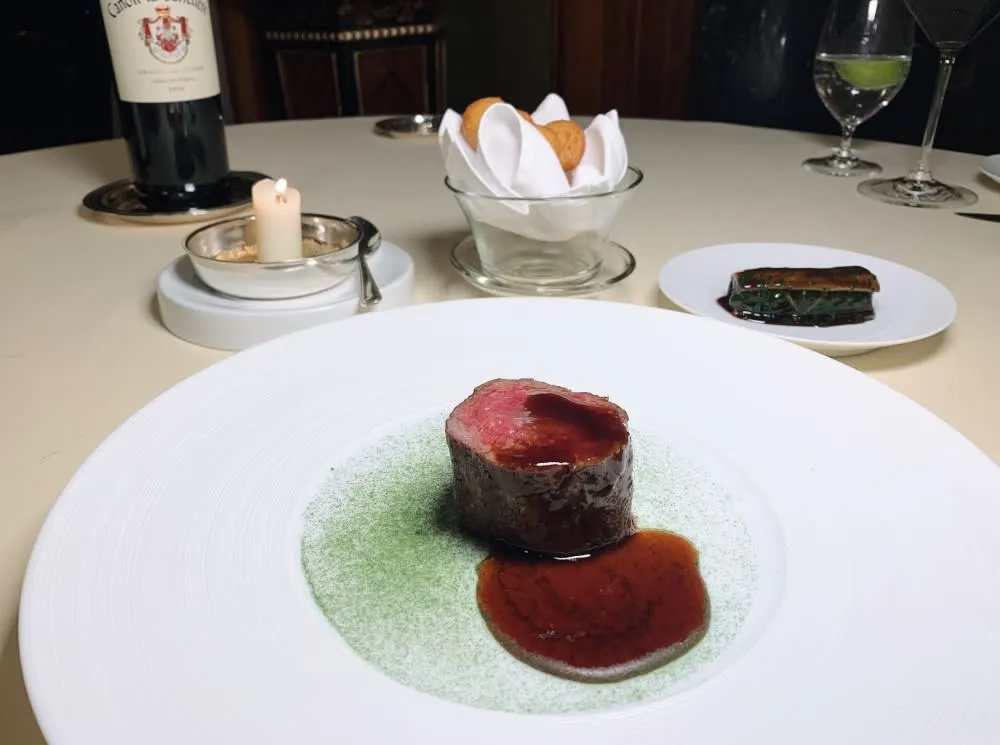 Rich beef main course featuring the calotte cut and an innovative bone marrow candle, a signature of the petrus restaurant menu