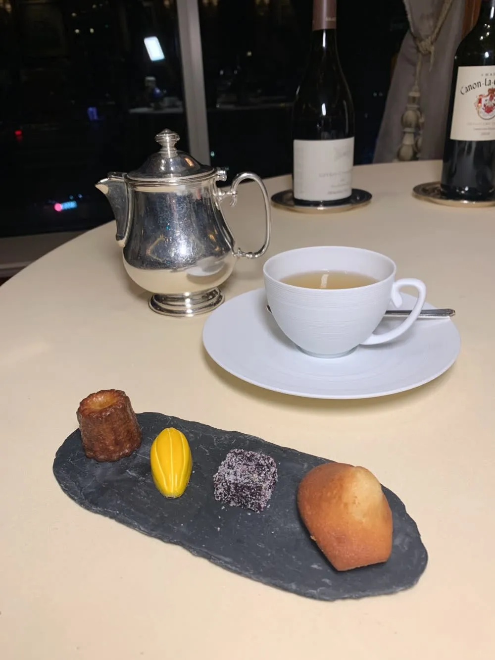 Artful display of Petits Fours including canelé and passion-fruit chocolate, concluding the petrus restaurant menu degustation
