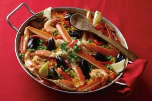 Vibrant seafood paella in a traditional pan, a centerpiece of the traditions restaurant menu