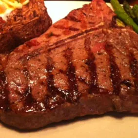 A perfectly cooked 20 oz. T-Bone Porterhouse Steak, a highlight of the Marion restaurant menu's beef selection.