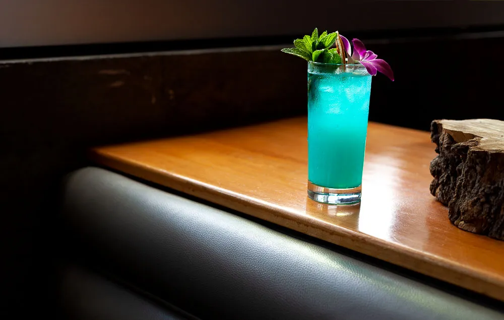 A decorative vase of flowers sits on a wooden table, suggesting a pleasant, relaxed dining environment.