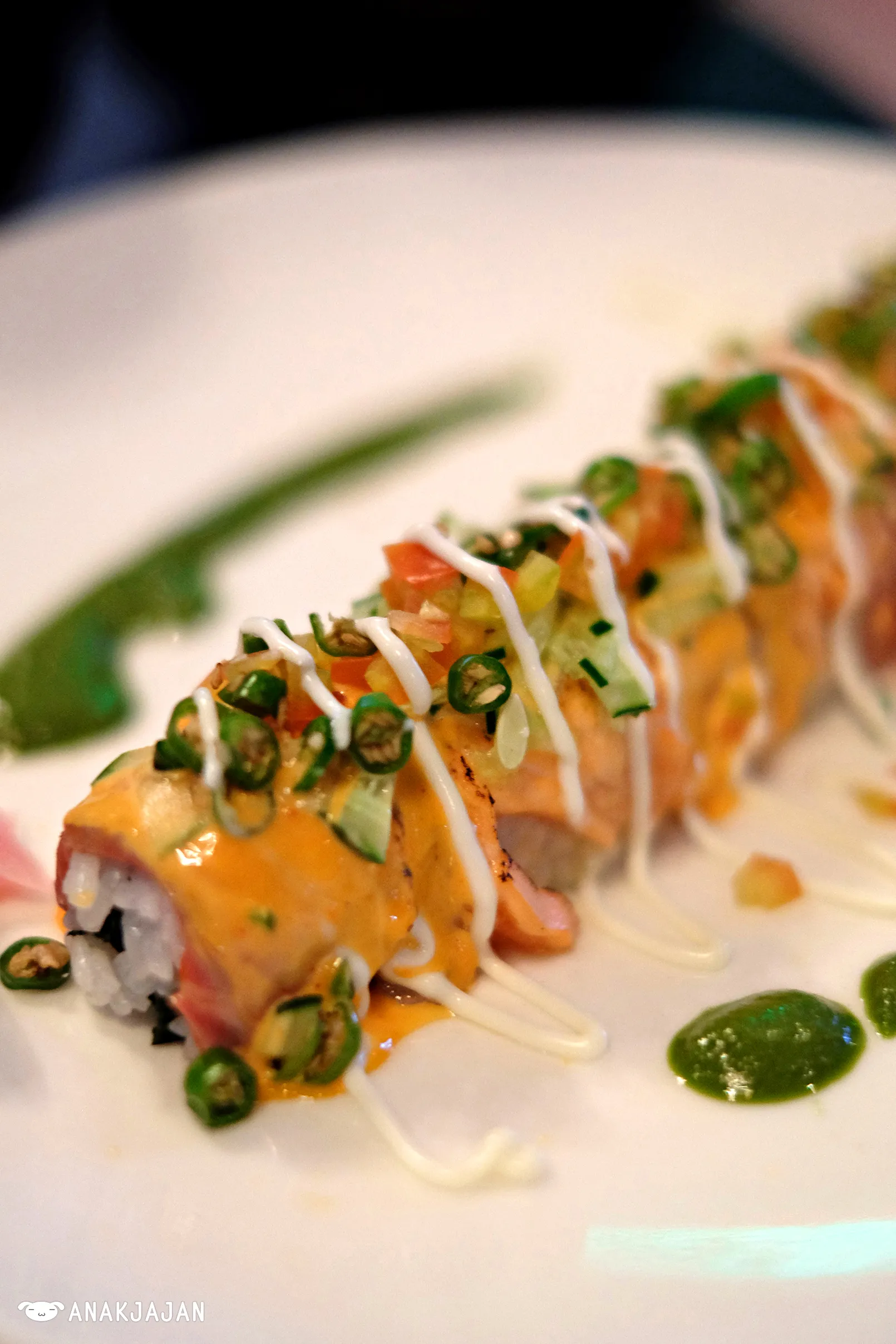 Spicy Salmon Samba Roll sliced and presented, topped with salmon and visible chili flakes