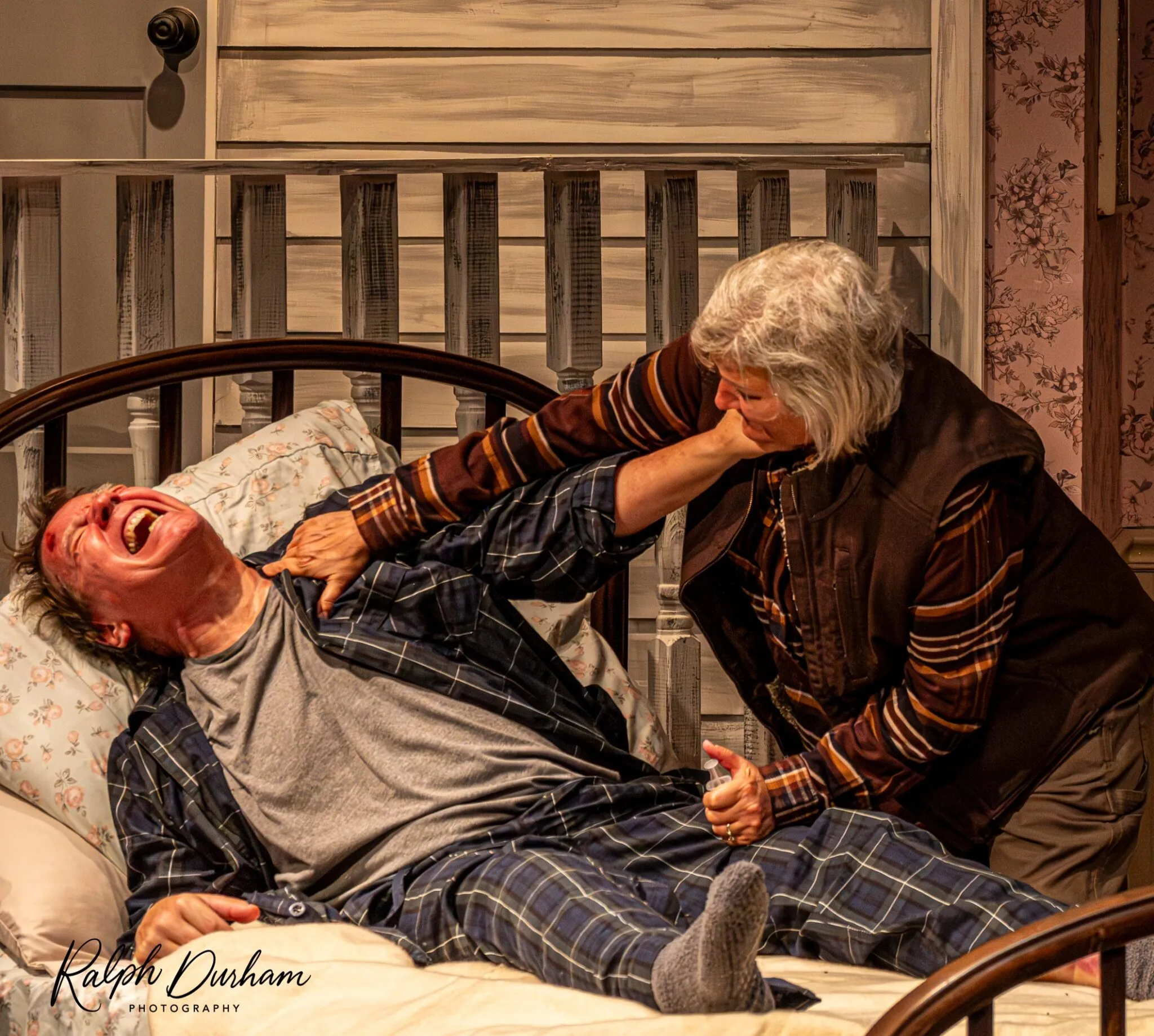 An intense scene between two actors on the stage of Citadel Theatre's production of Misery. This demonstrates the dramatic quality of the performance.