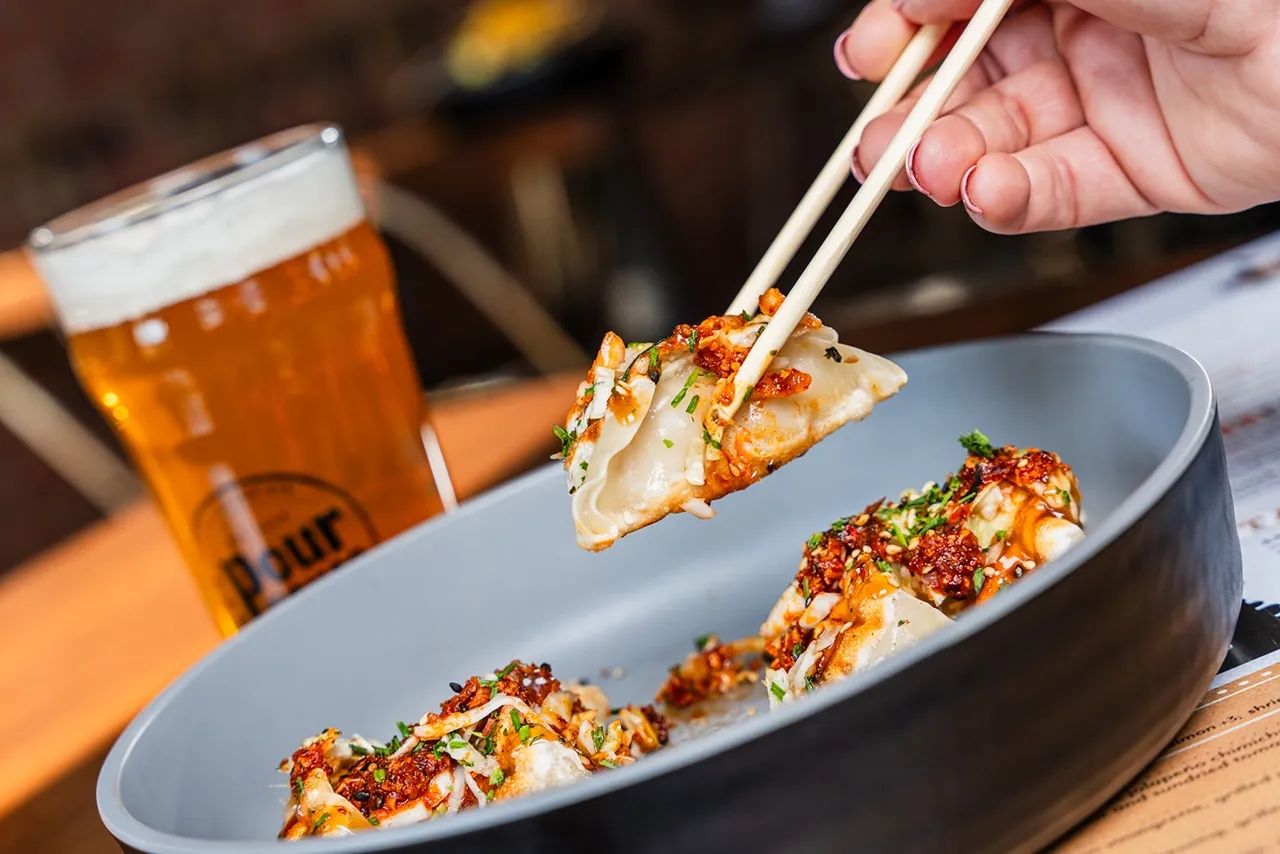 Crispy Asian Potstickers from The Pour House, topped with a custom-made chili crisp, illustrating the integration of intense umami on a casual dining umami restaurant menu